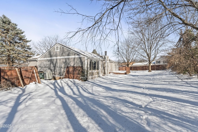 snow covered property with central AC