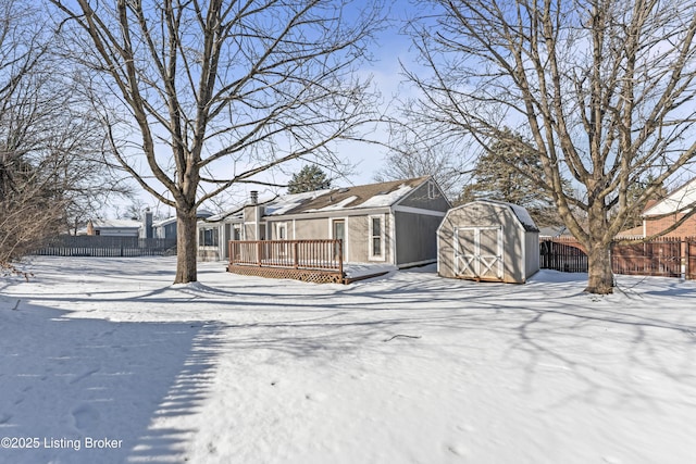 view of front of property featuring a storage unit and a wooden deck