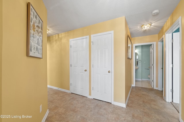 hall featuring a textured ceiling