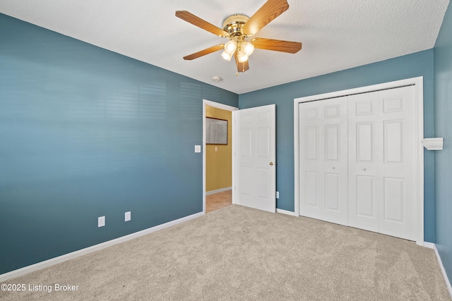 unfurnished bedroom featuring ceiling fan, light carpet, a closet, and a textured ceiling