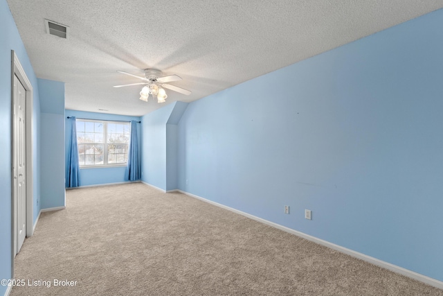 unfurnished room with ceiling fan, light carpet, and a textured ceiling