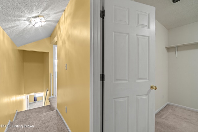 interior space featuring light colored carpet and a textured ceiling