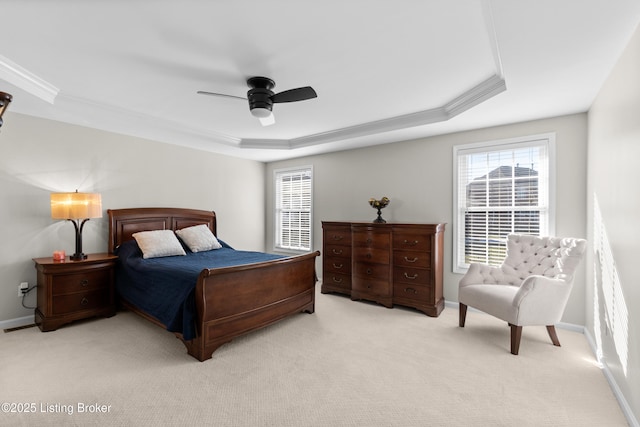 carpeted bedroom with crown molding, ceiling fan, and a raised ceiling