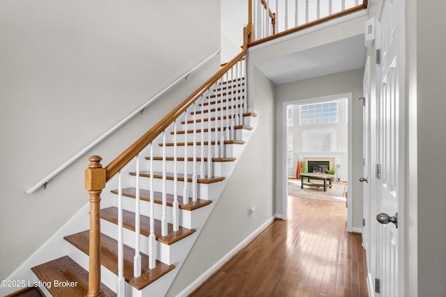 stairs featuring hardwood / wood-style flooring and a high ceiling