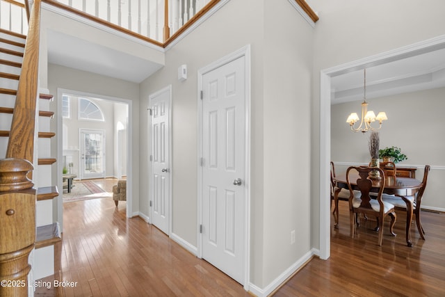 entrance foyer with an inviting chandelier, hardwood / wood-style flooring, and a high ceiling