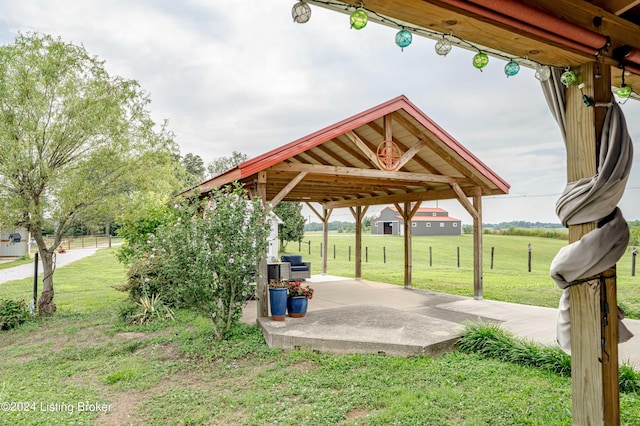 view of home's community featuring a gazebo, a yard, a rural view, and a patio