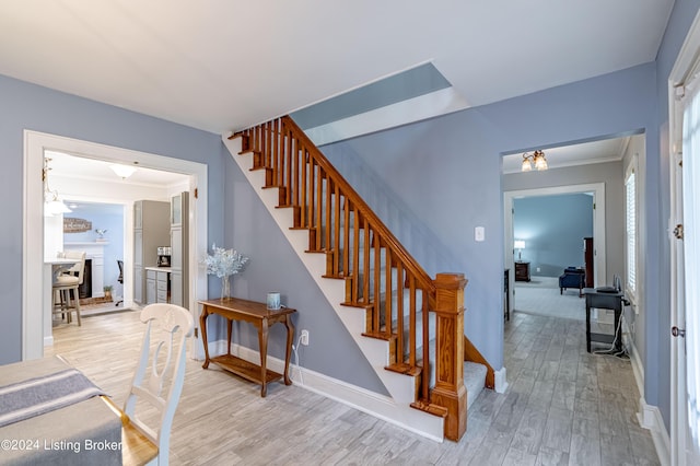 stairway featuring crown molding and hardwood / wood-style floors