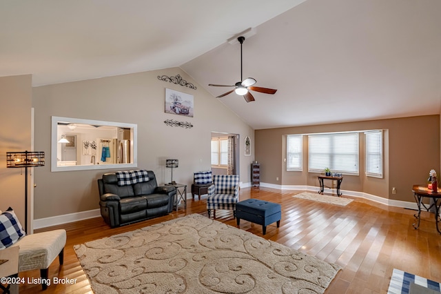 living room featuring ceiling fan, lofted ceiling, and light wood-type flooring