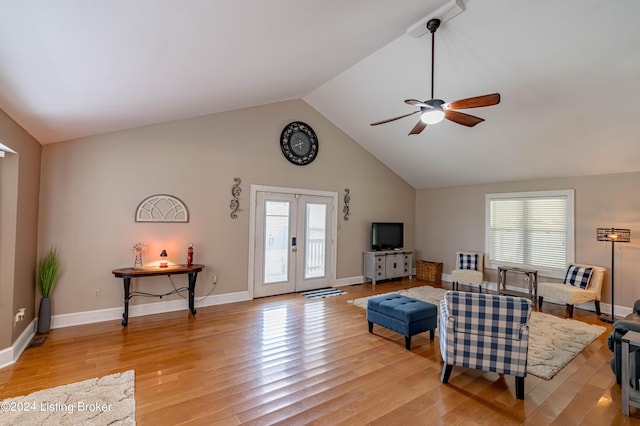 living room featuring ceiling fan, vaulted ceiling, french doors, and light wood-type flooring