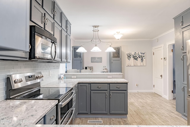 kitchen featuring stainless steel appliances, gray cabinetry, ornamental molding, pendant lighting, and light stone counters