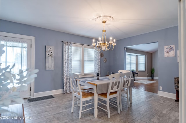 dining room with wood-type flooring and a chandelier