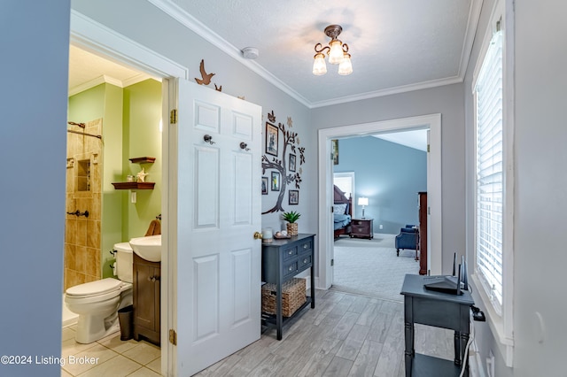 hall with a chandelier, crown molding, and light hardwood / wood-style flooring