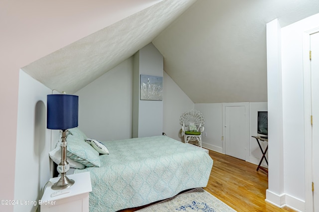 bedroom with lofted ceiling and hardwood / wood-style flooring