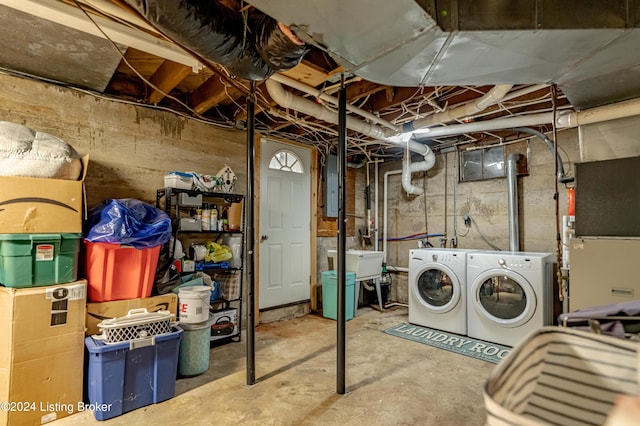 basement with separate washer and dryer, electric panel, and sink