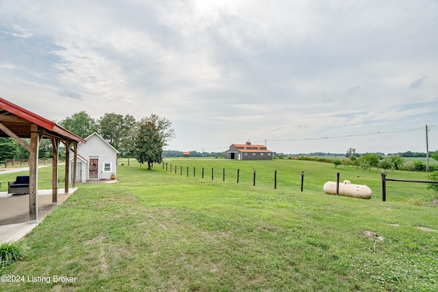 view of yard with an outbuilding and a rural view