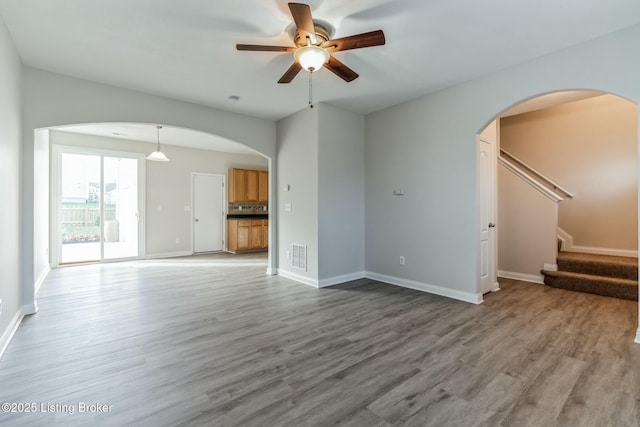 unfurnished living room with ceiling fan and hardwood / wood-style floors