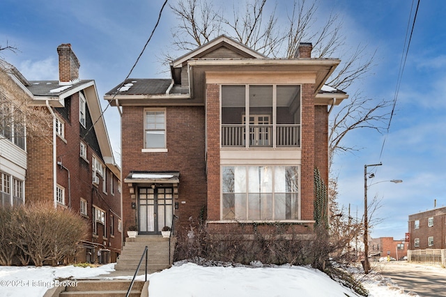 view of front of house featuring brick siding and a chimney