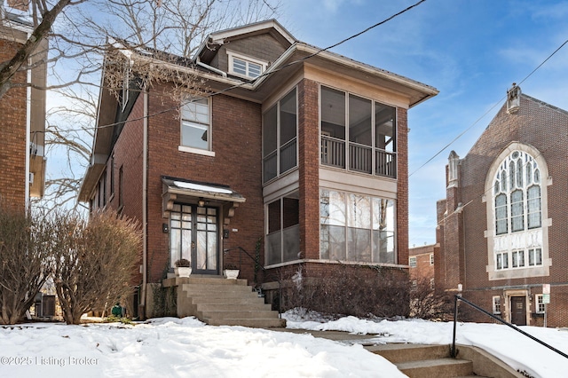 view of front facade featuring a sunroom and brick siding