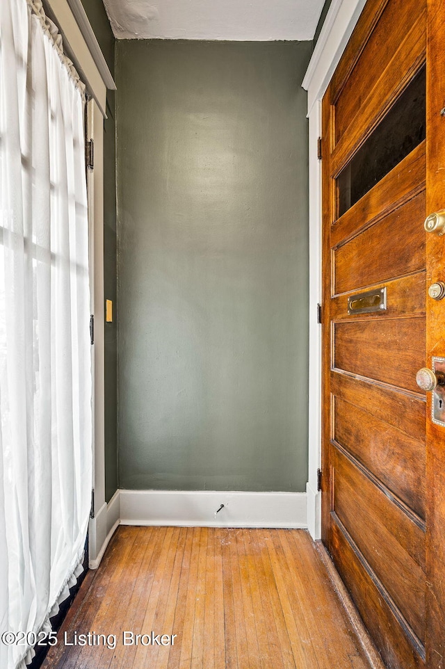 unfurnished room with wood-type flooring and baseboards