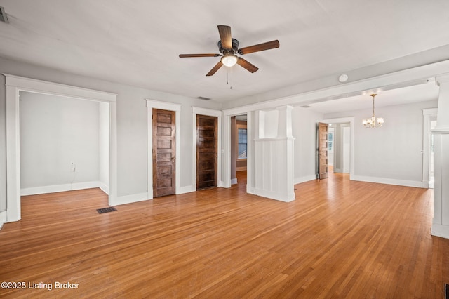 unfurnished living room featuring light wood-style floors, visible vents, baseboards, and ceiling fan with notable chandelier