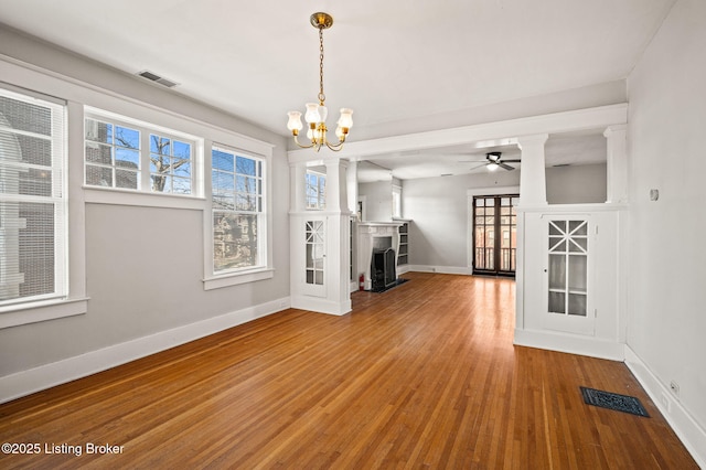 interior space featuring baseboards, a fireplace, visible vents, and wood finished floors