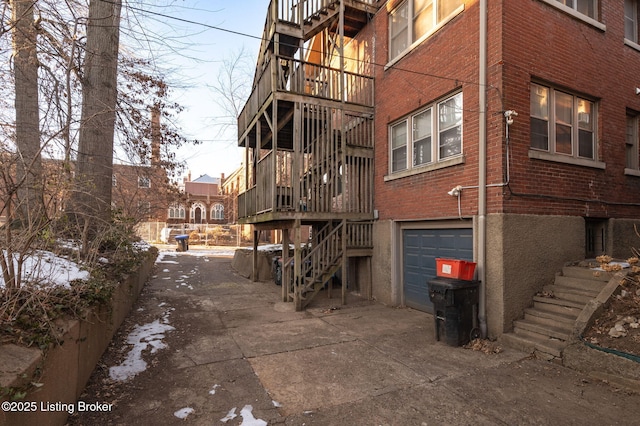 view of building exterior featuring a garage, driveway, and stairway