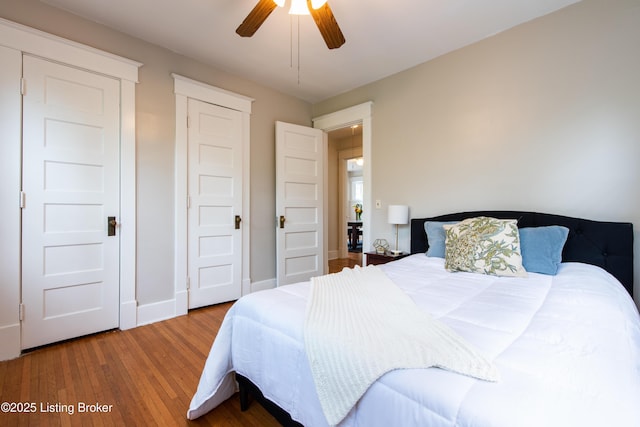 bedroom featuring ceiling fan, baseboards, and wood finished floors