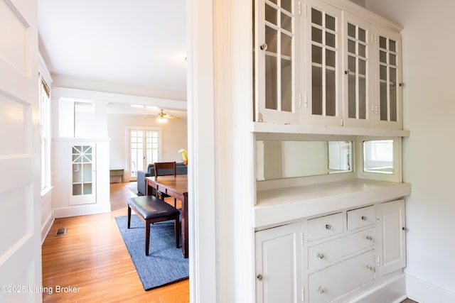 interior space featuring visible vents, a ceiling fan, and wood finished floors