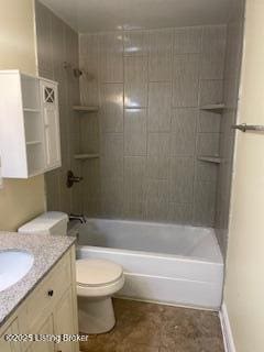 full bathroom featuring tiled shower / bath combo, vanity, and toilet