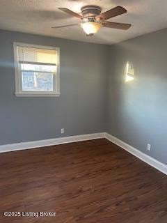 spare room with dark wood-type flooring and ceiling fan