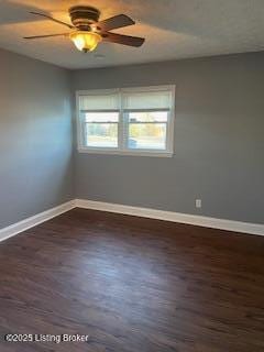 empty room with ceiling fan and dark hardwood / wood-style flooring