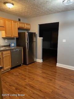 kitchen featuring dark wood-type flooring, stainless steel appliances, sink, and a textured ceiling