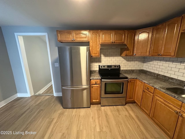 kitchen with sink, backsplash, light hardwood / wood-style flooring, and stainless steel appliances