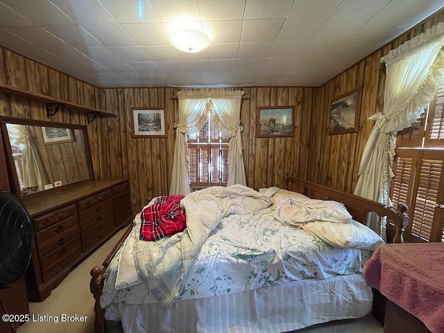 carpeted bedroom featuring wooden walls