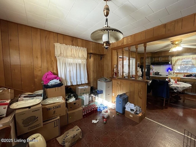 miscellaneous room featuring ceiling fan and wood walls