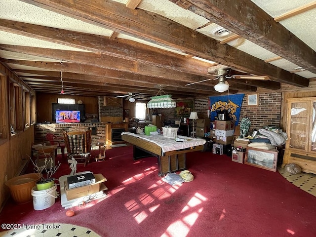 interior space featuring ceiling fan, brick wall, and carpet flooring