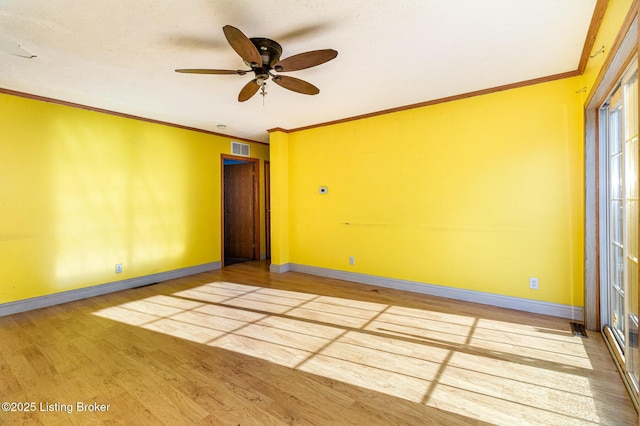 empty room featuring ceiling fan, wood-type flooring, and ornamental molding