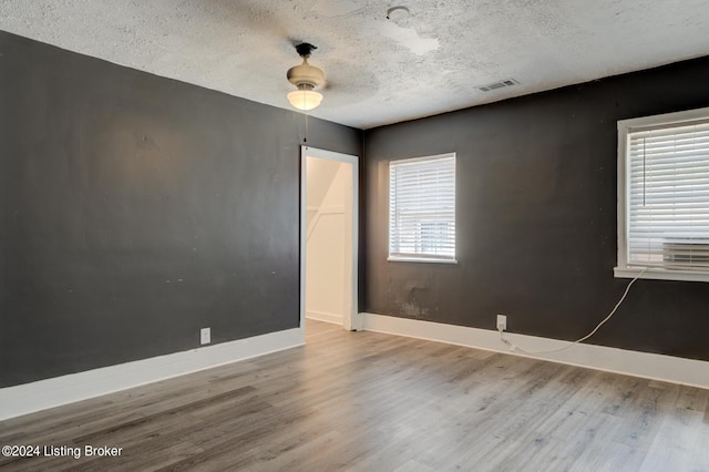 unfurnished room featuring a textured ceiling and light hardwood / wood-style flooring