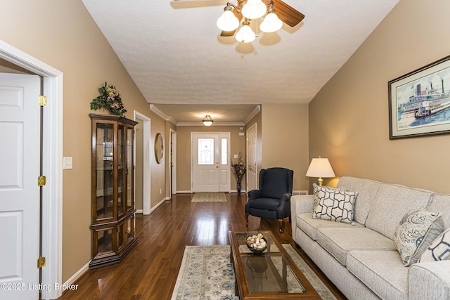 living room featuring ceiling fan, ornamental molding, dark hardwood / wood-style flooring, and a textured ceiling