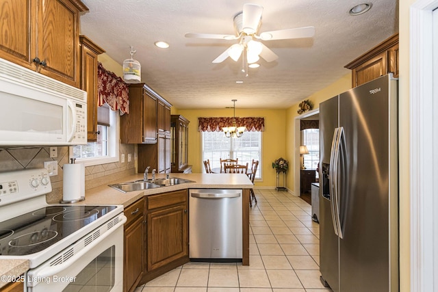 kitchen featuring sink, decorative light fixtures, backsplash, light tile patterned floors, and stainless steel appliances