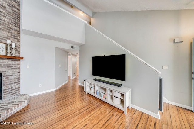 living room featuring a brick fireplace and light hardwood / wood-style floors