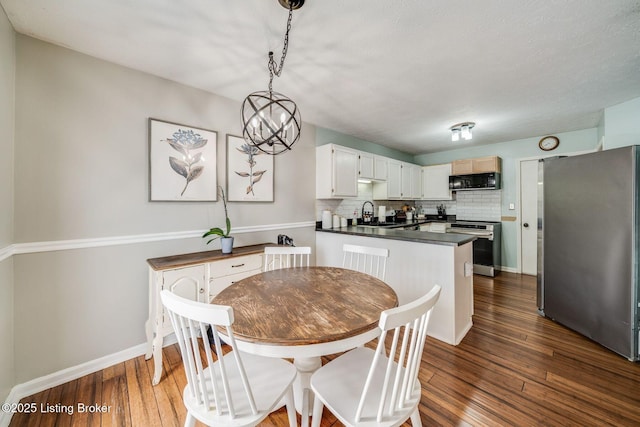 dining room featuring dark hardwood / wood-style flooring, a chandelier, and sink