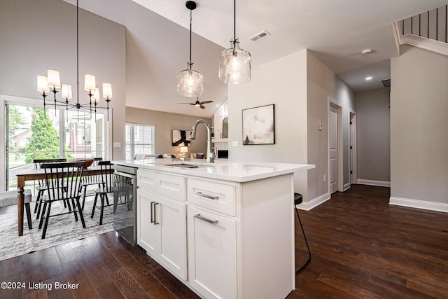 111 Wellston Pl, Louisville, KY 40207 - kitchen with white cabinets, decorative light fixtures, sink, a center island with sink, and dark hardwood / wood-style floors