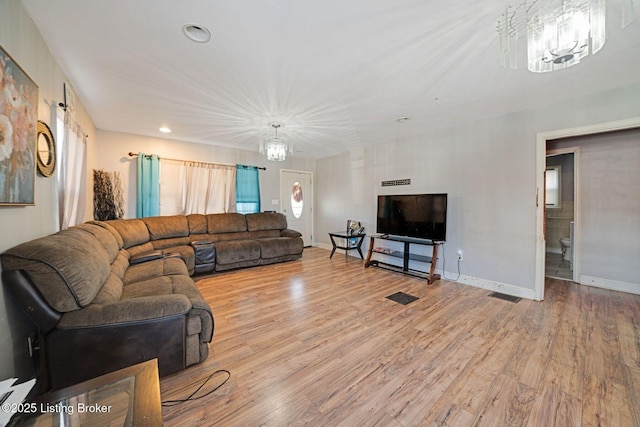 living room featuring a chandelier and light hardwood / wood-style flooring