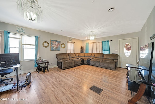 living room with light hardwood / wood-style flooring and a chandelier