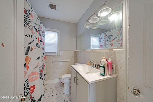 bathroom featuring toilet, vanity, tile walls, and a shower with curtain