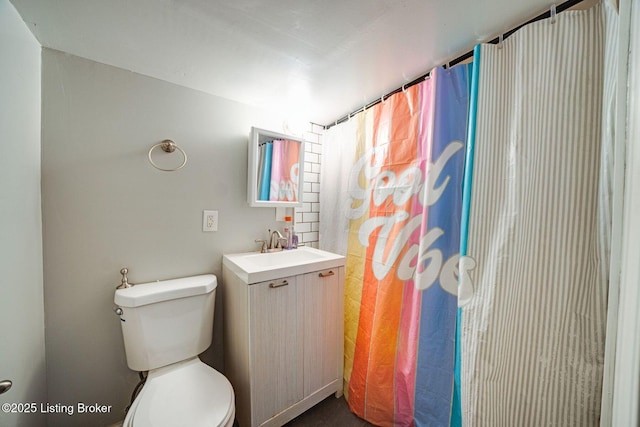 bathroom with toilet, walk in shower, and vanity