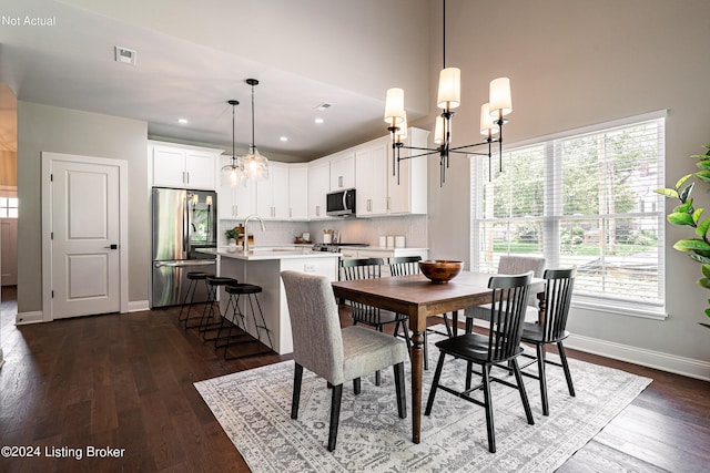 dining area with a notable chandelier, dark hardwood / wood-style floors, and sink