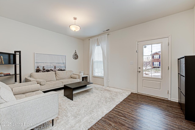 living room with a healthy amount of sunlight and dark hardwood / wood-style flooring