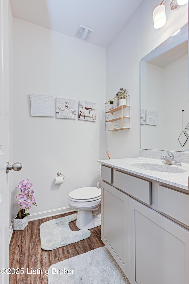 bathroom featuring hardwood / wood-style flooring, vanity, and toilet